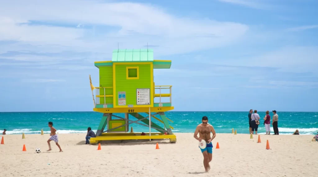 Lummus Park Beach Miami, vista com coqueiros e areia branca em South Beach – cartão-postal de Miami Beach.