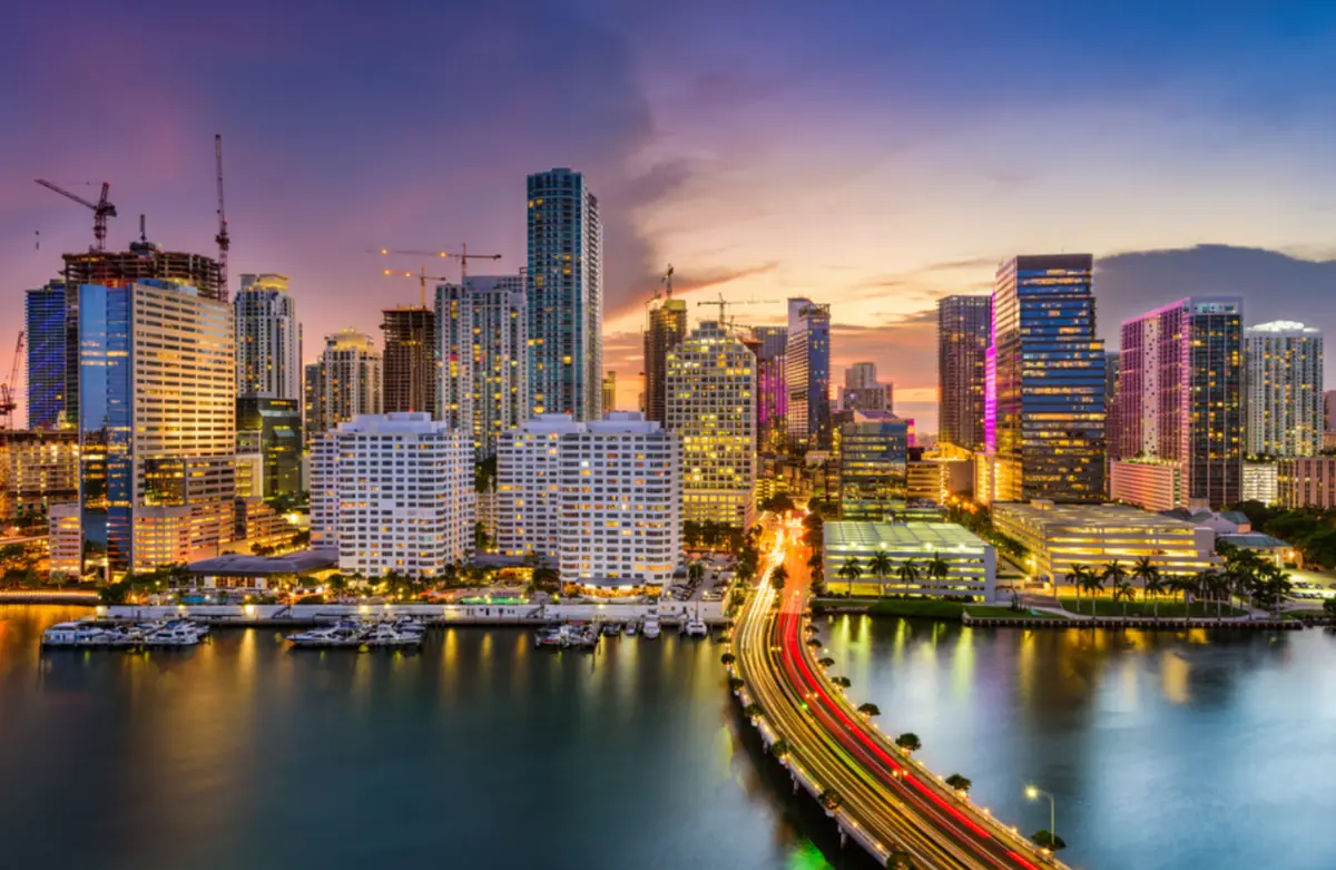 Onde Fica Miami- Vista noturna do centro de Miami com prédios iluminados, ponte sobre a baía e skyline moderno da cidade