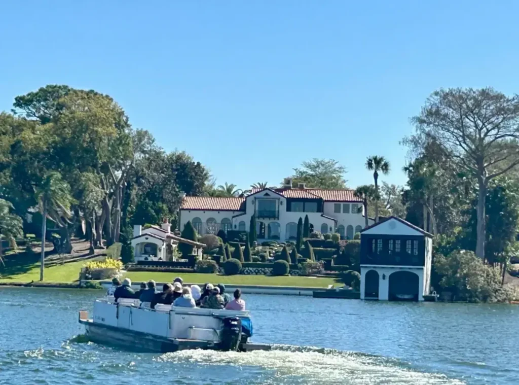 Passeio de barco pelos lagos de Winter Park com vista para mansões e propriedades à beira d’água.